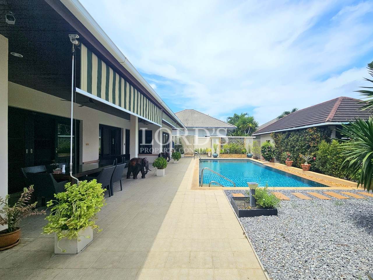 Luxury home with a private swimming pool, covered patio, and landscaped garden