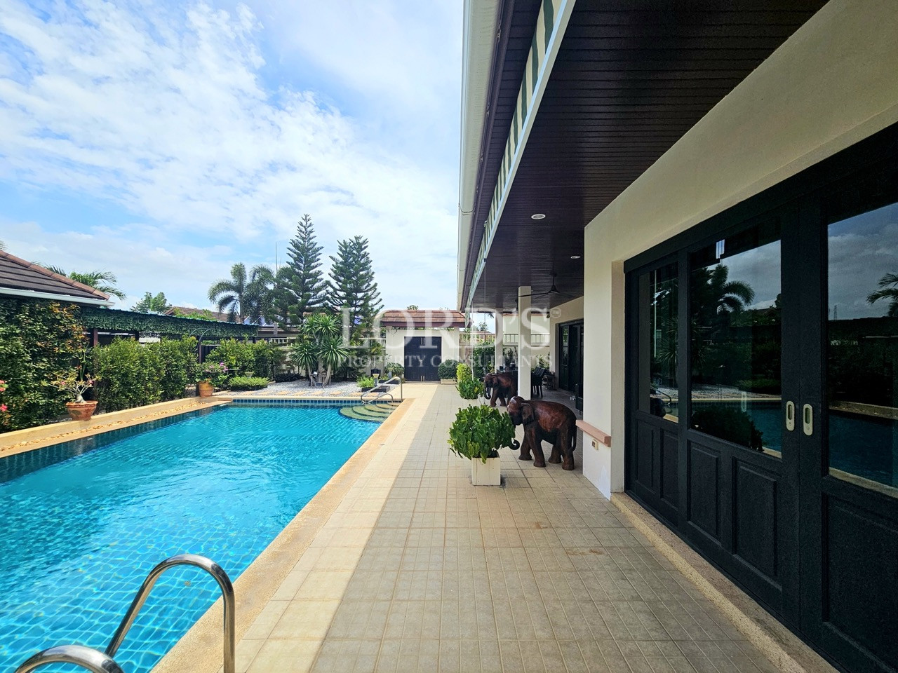 Private swimming pool with poolside walkway and direct access to the covered terrace