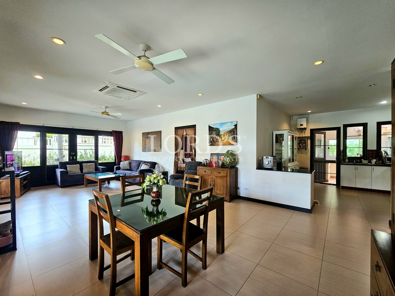 Open-plan living, dining, and kitchen area with modern furnishings and abundant natural light