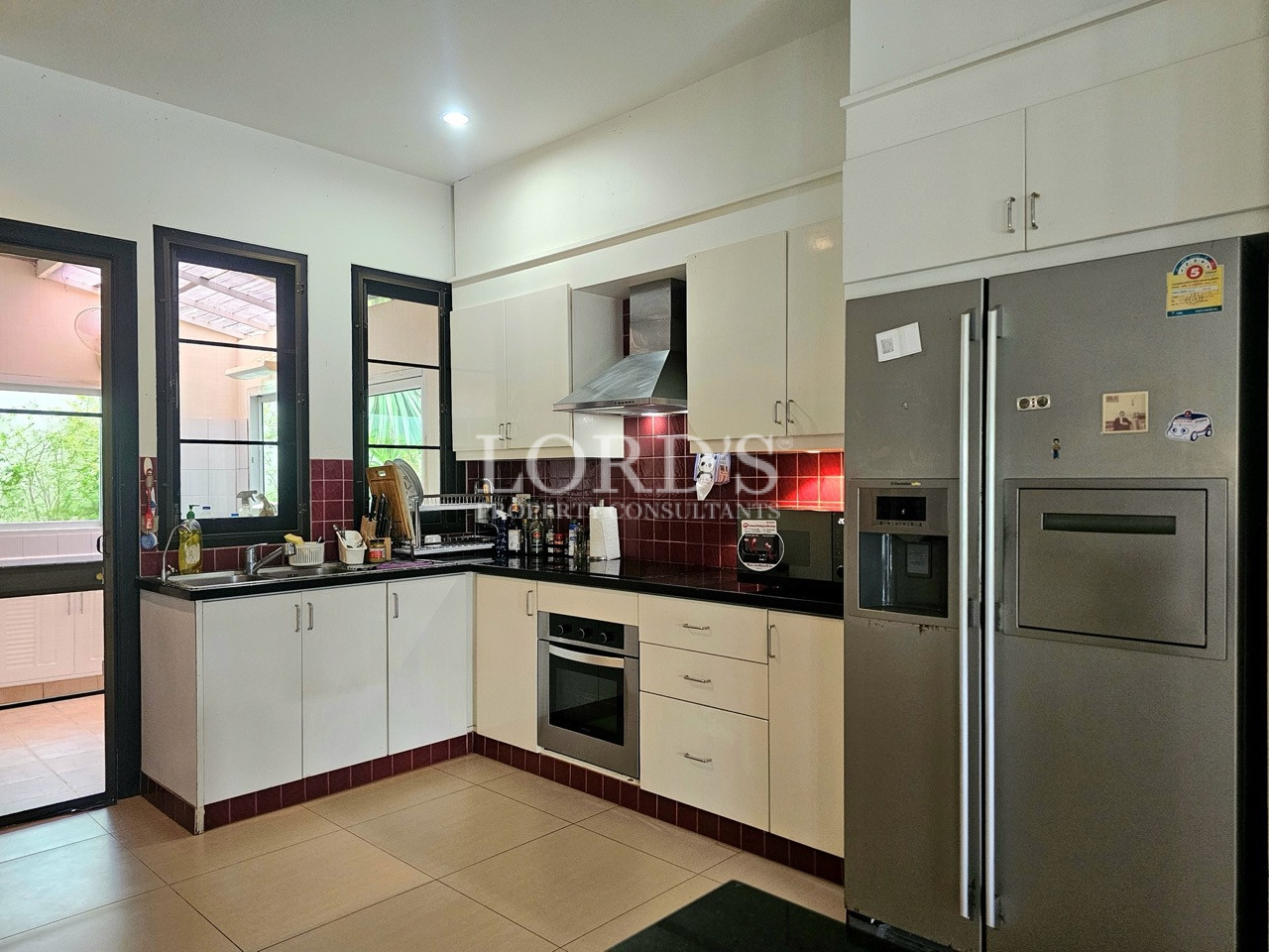 Modern fitted kitchen with built-in appliances, side-by-side refrigerator, and custom cabinetry