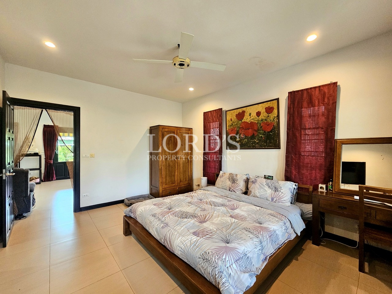 Bright master bedroom with wooden furniture, ceiling fan, and spacious layout
