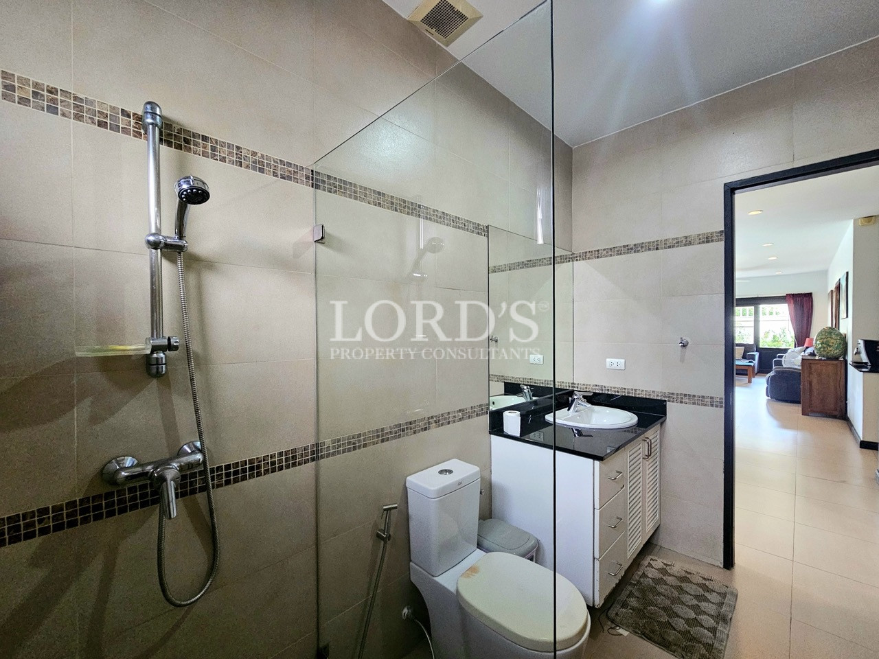 Modern bathroom with a glass-enclosed shower, vanity sink, and contemporary tiled finishes