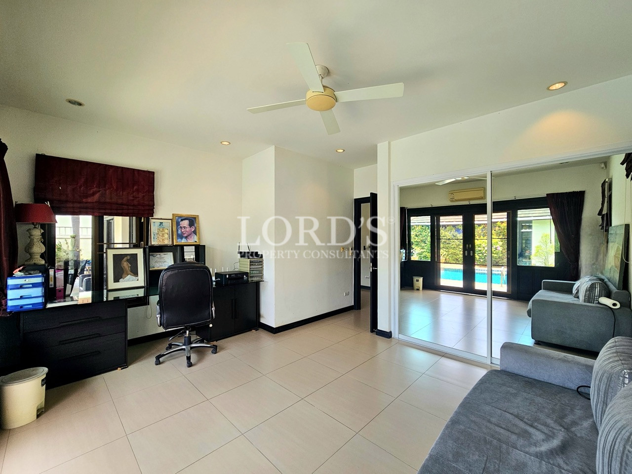 Home office and guest bedroom with built-in workspace, mirrored wardrobe, and pool views