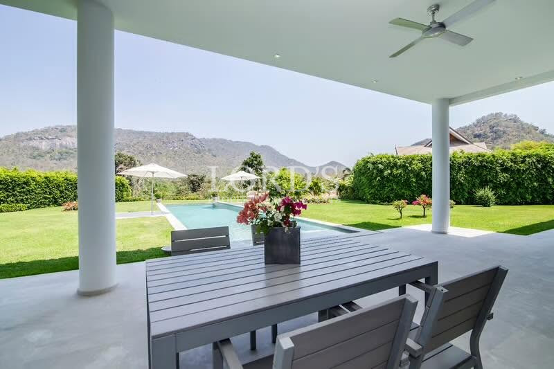 Covered terrace overlooking landscaped lawn and mountain scenery