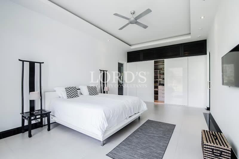 Modern minimalist bedroom with ceiling fan and built-in wardrobe