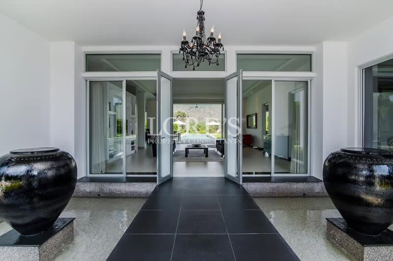 Modern entrance with large glass doors and elegant chandelier