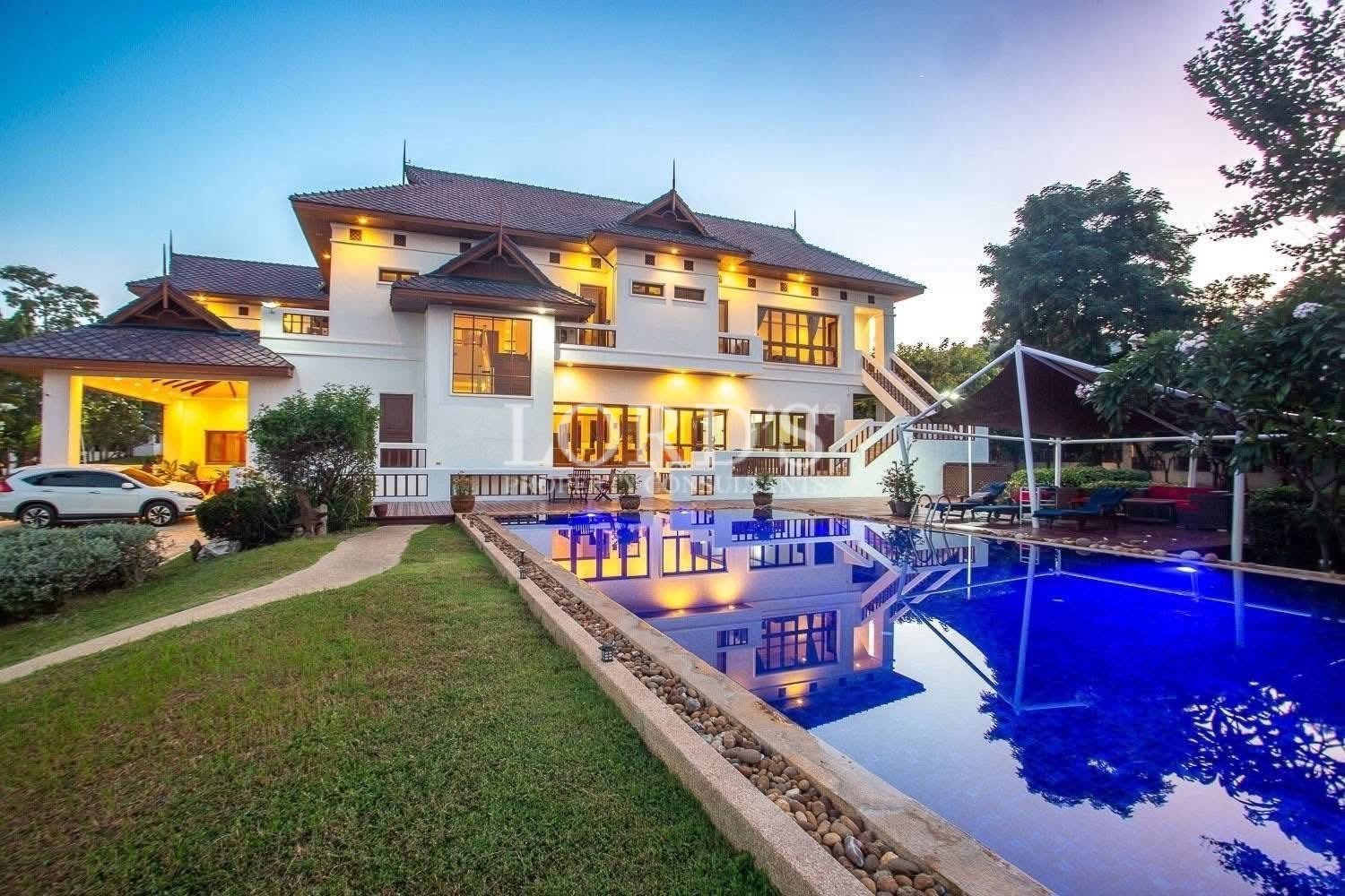 Luxury multi-story house with landscaped front yard at dusk