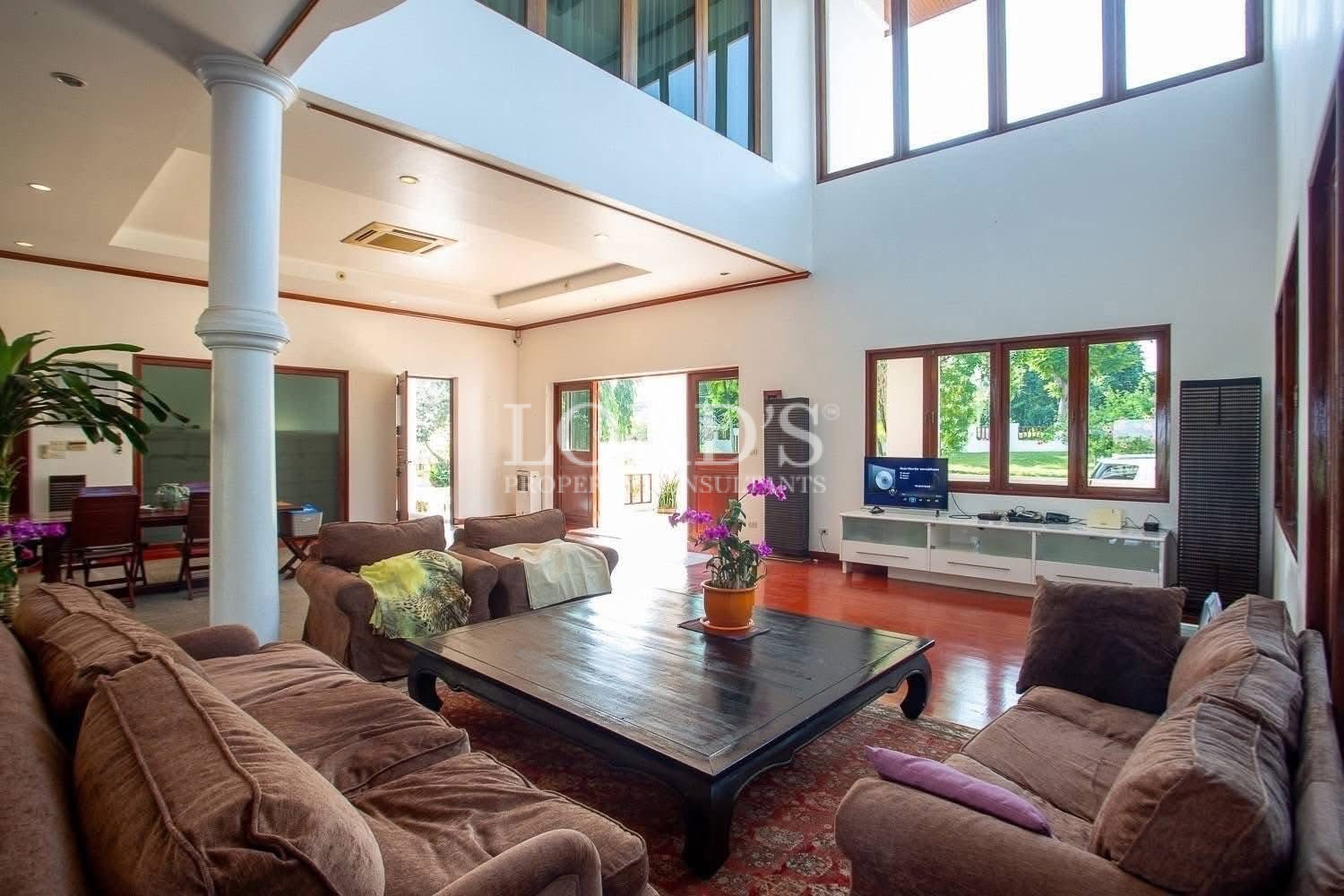 Open-plan living area with high ceiling and large glass windows