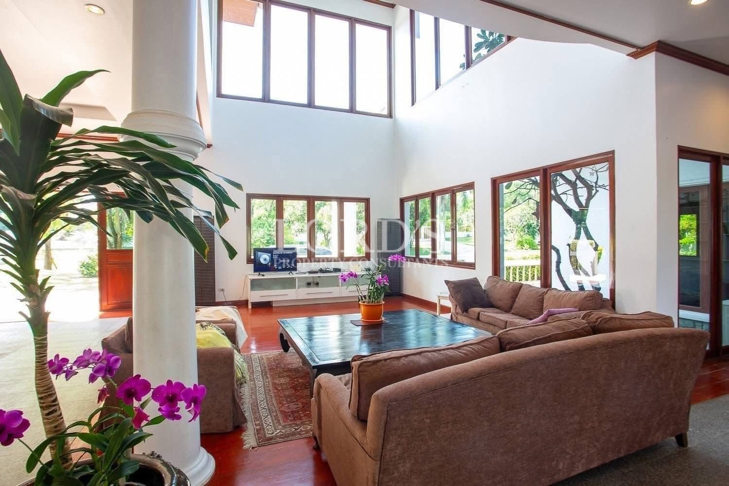 Bright living room with large windows overlooking outdoor greenery