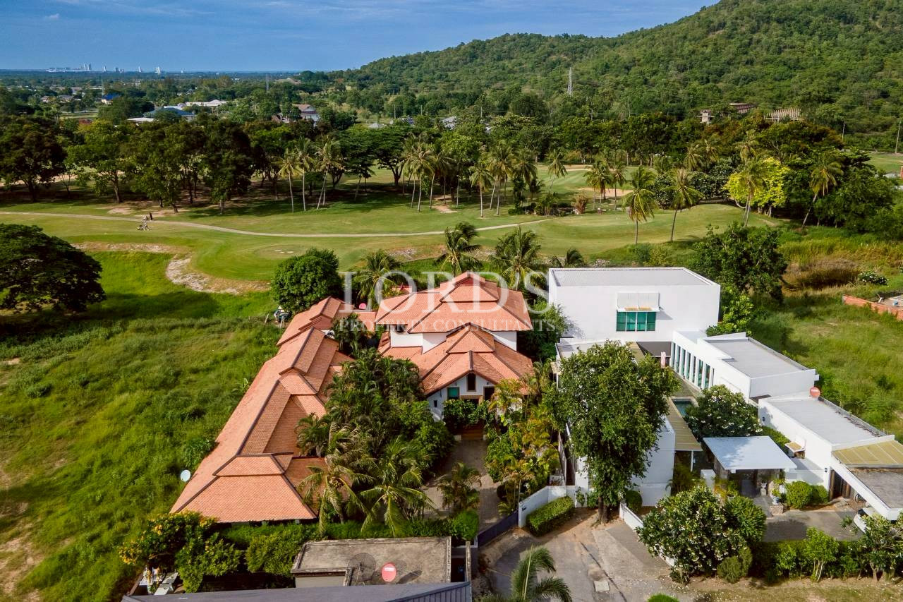 Tropical villa surrounded by lush palm trees and landscaped garden