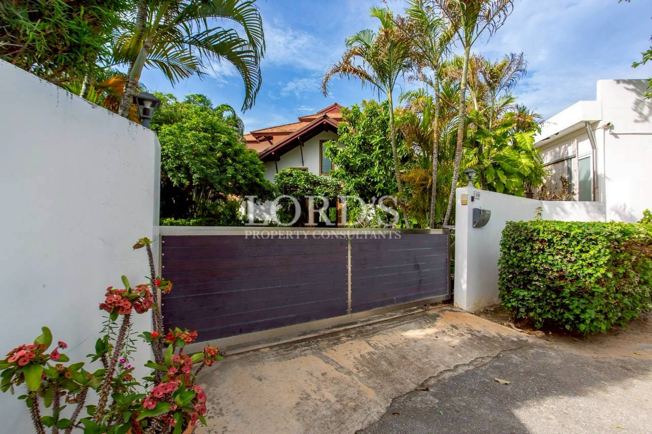 Luxury tropical villa surrounded by palm trees and landscaped gardens