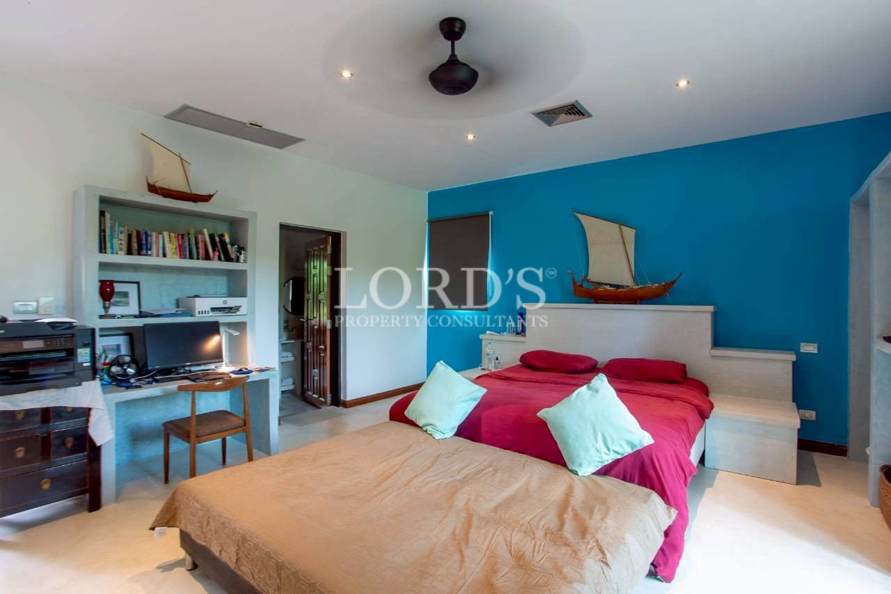 Bright bedroom with modern furnishings and ceiling fan