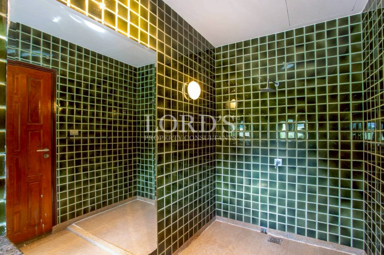 Modern bathroom with green mosaic tile walls and round lighting