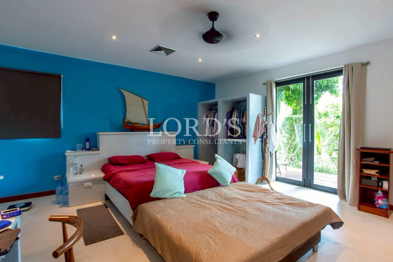 Colorful bedroom with blue accent wall and garden views
