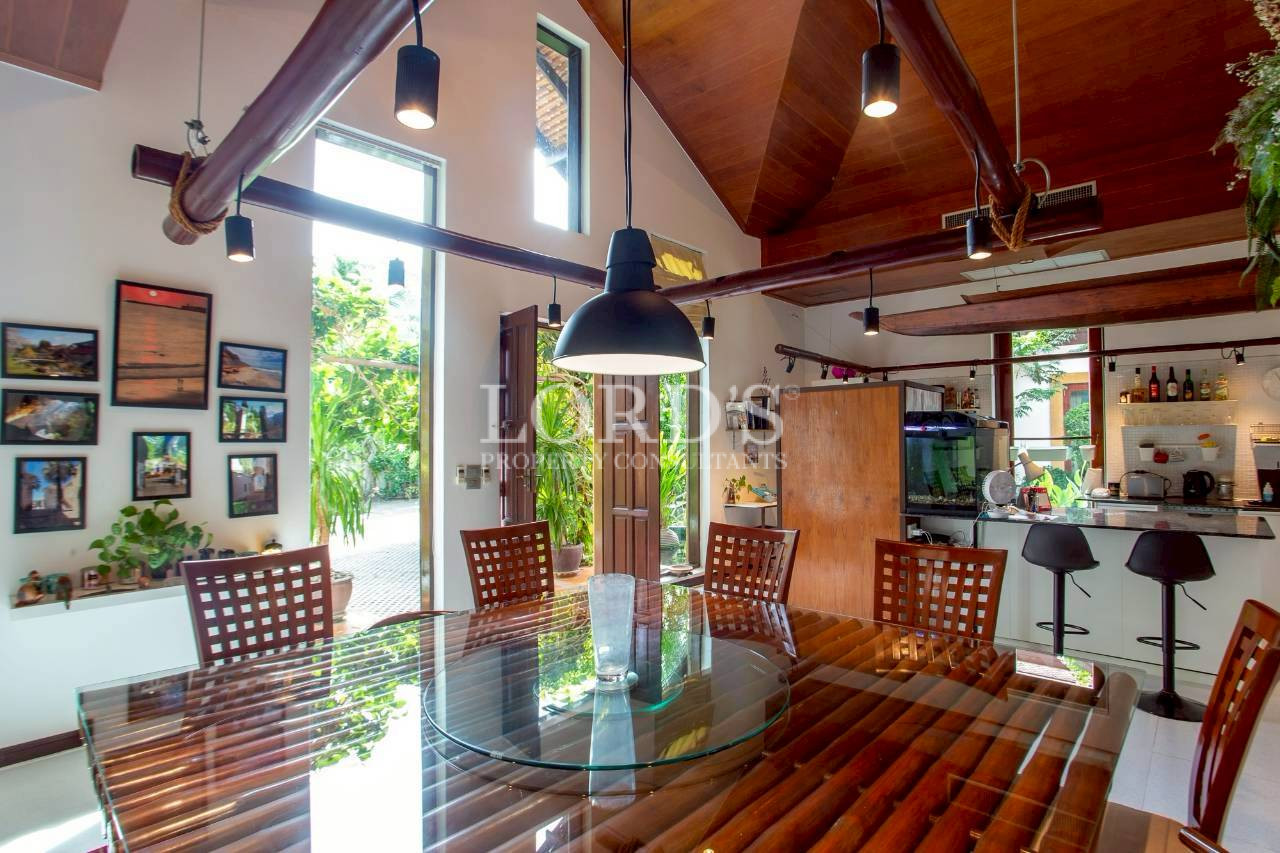 Covered outdoor patio with wooden ceiling overlooking tropical garden