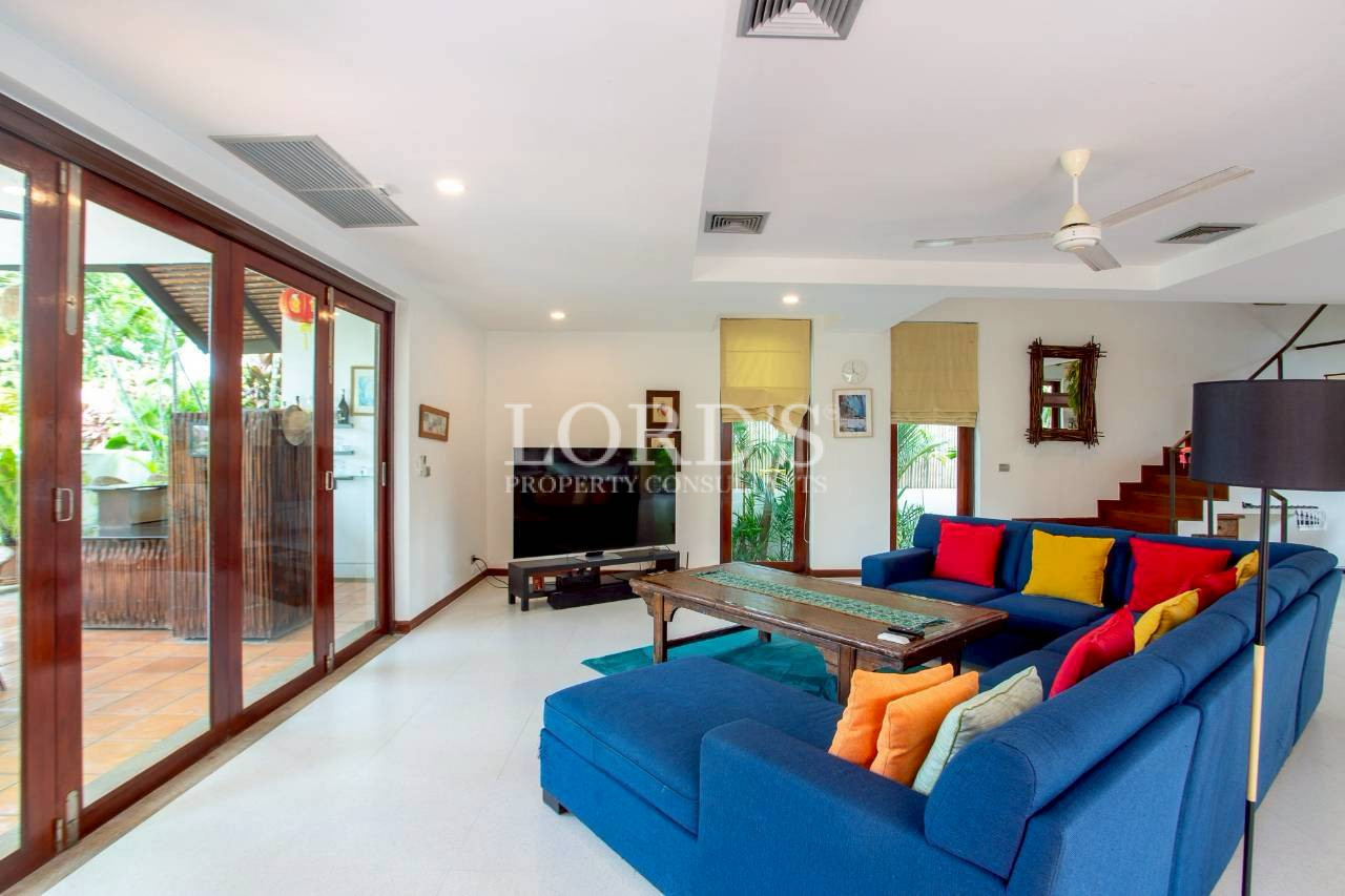 Bright open-plan living room with large windows and modern furnishings