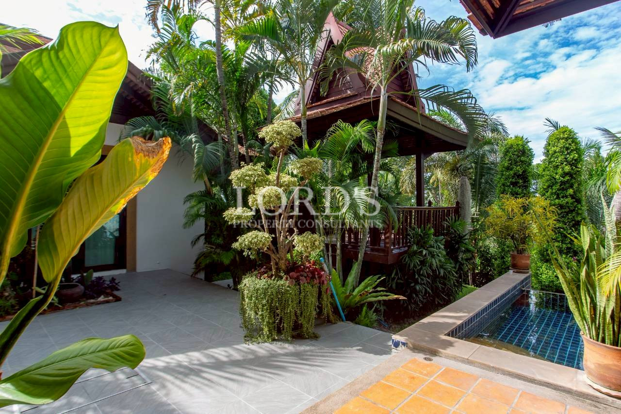 Traditional tropical pavilion surrounded by lush palm trees