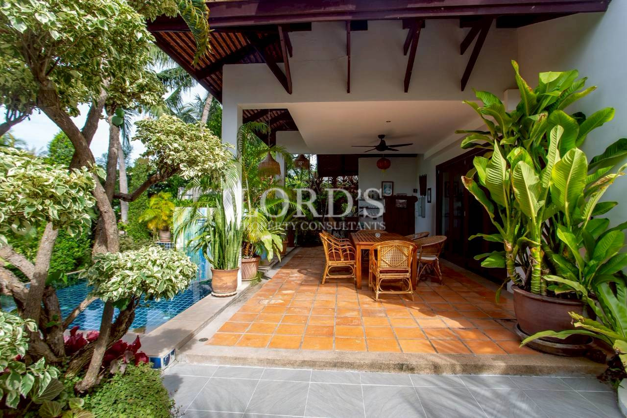 Covered outdoor patio with wooden ceiling and garden views