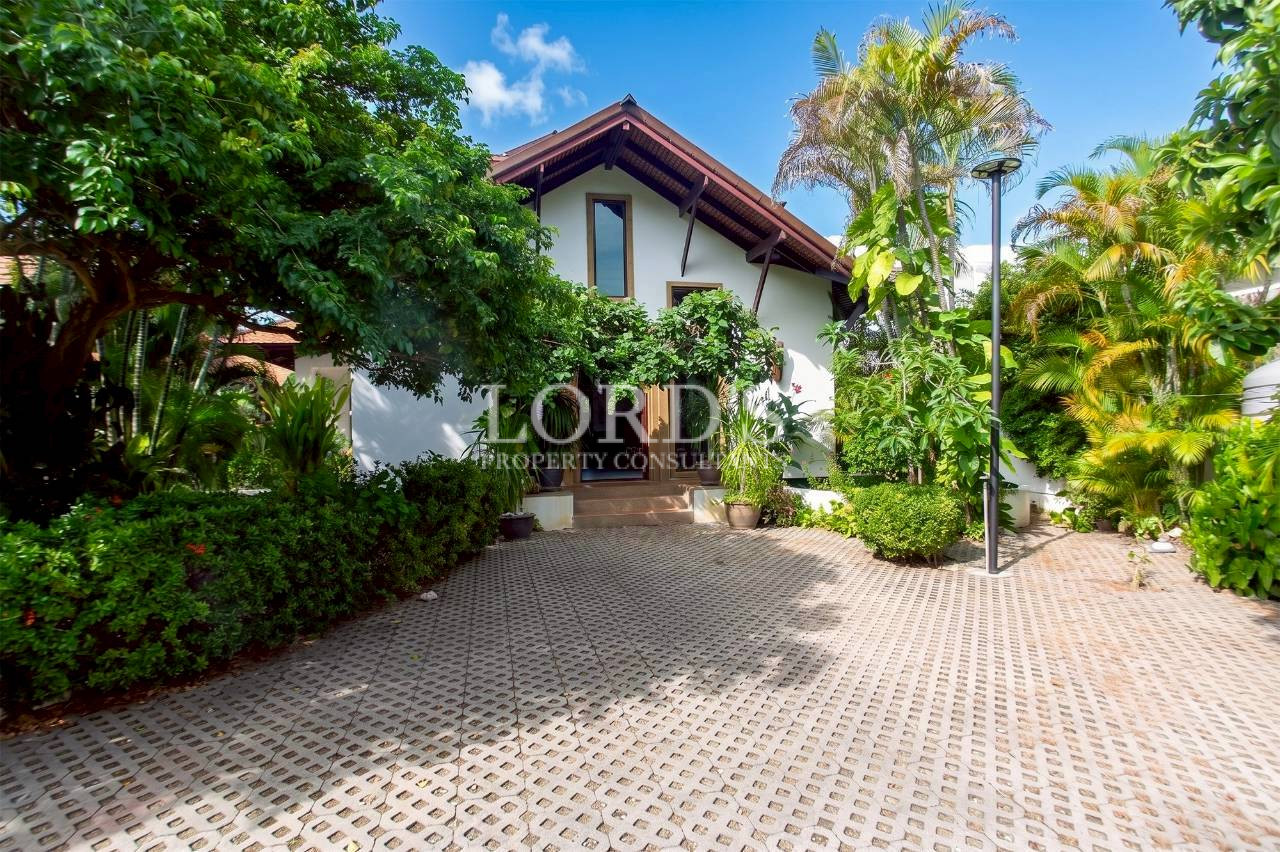Tropical villa surrounded by lush palm trees and landscaped garden