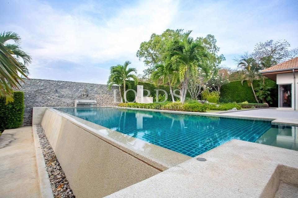 Infinity swimming pool surrounded by tropical trees