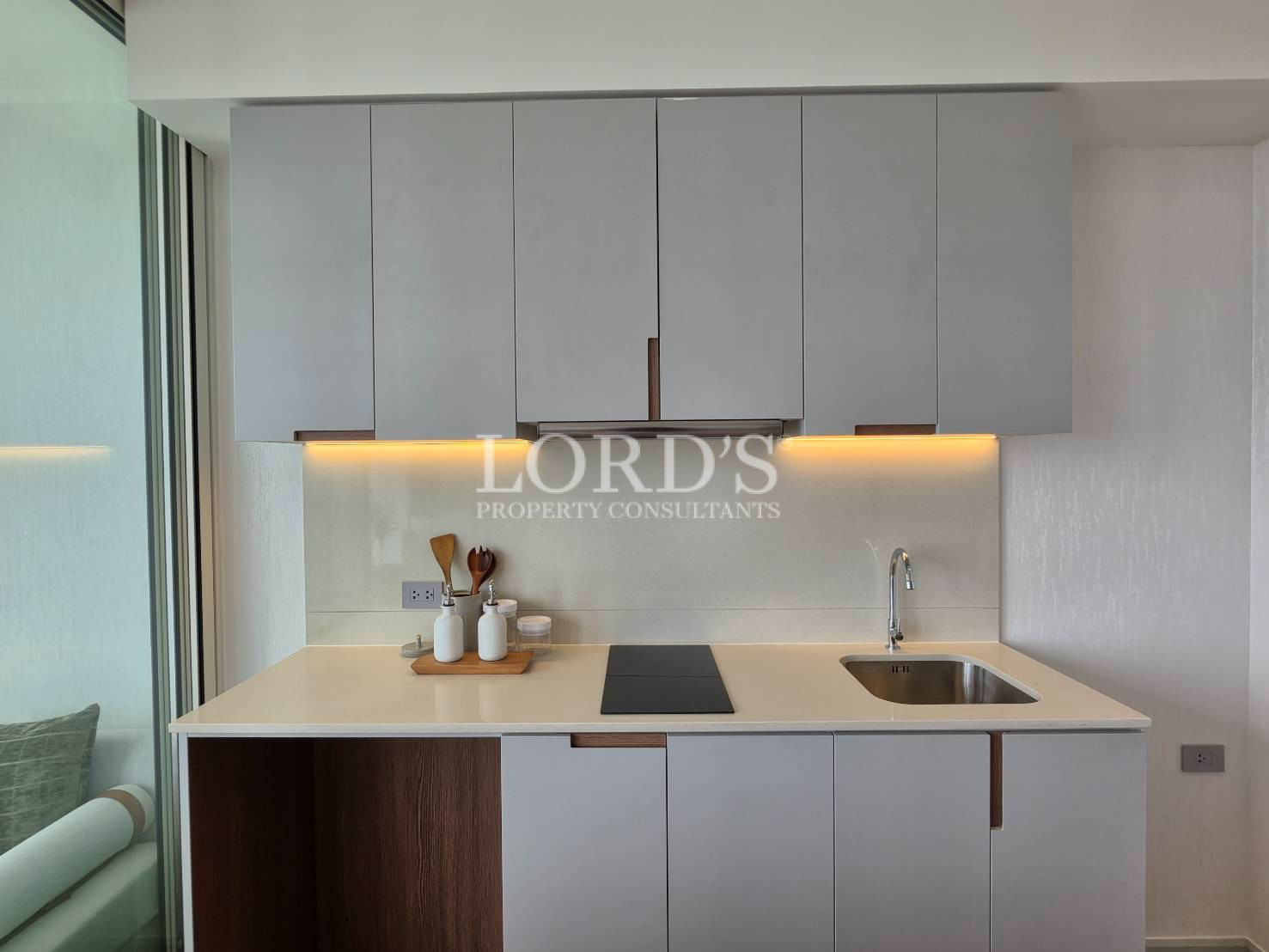 Modern kitchen with white cabinetry and warm under-cabinet lighting