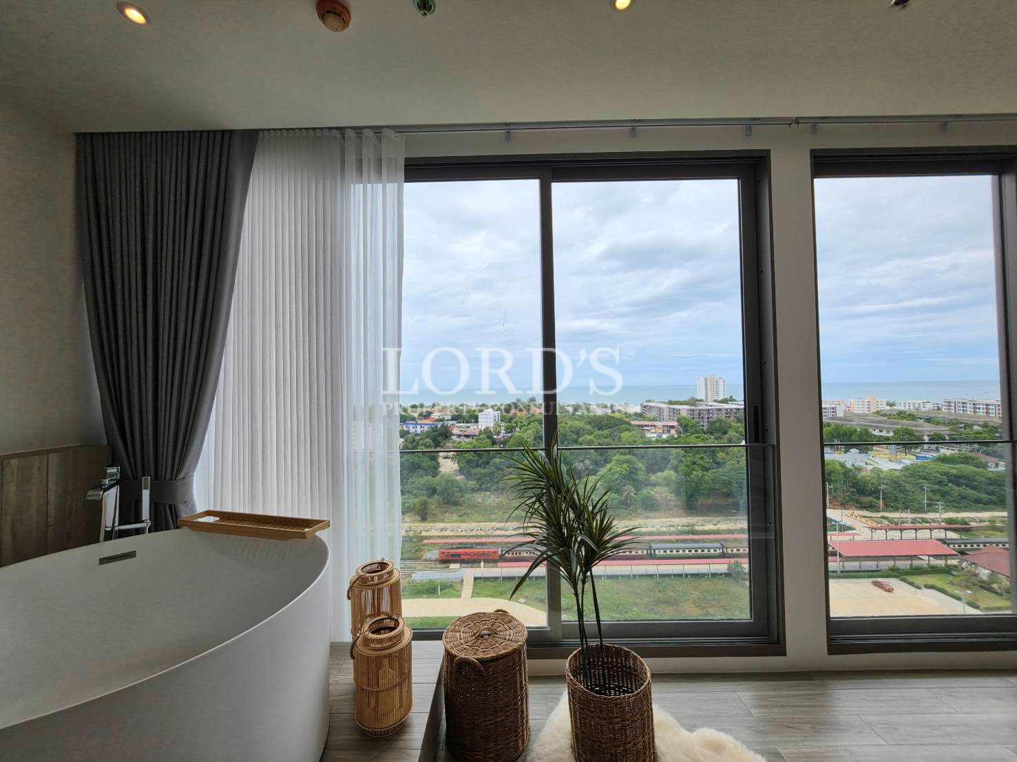 Modern bedroom with floor-to-ceiling window overlooking the city skyline