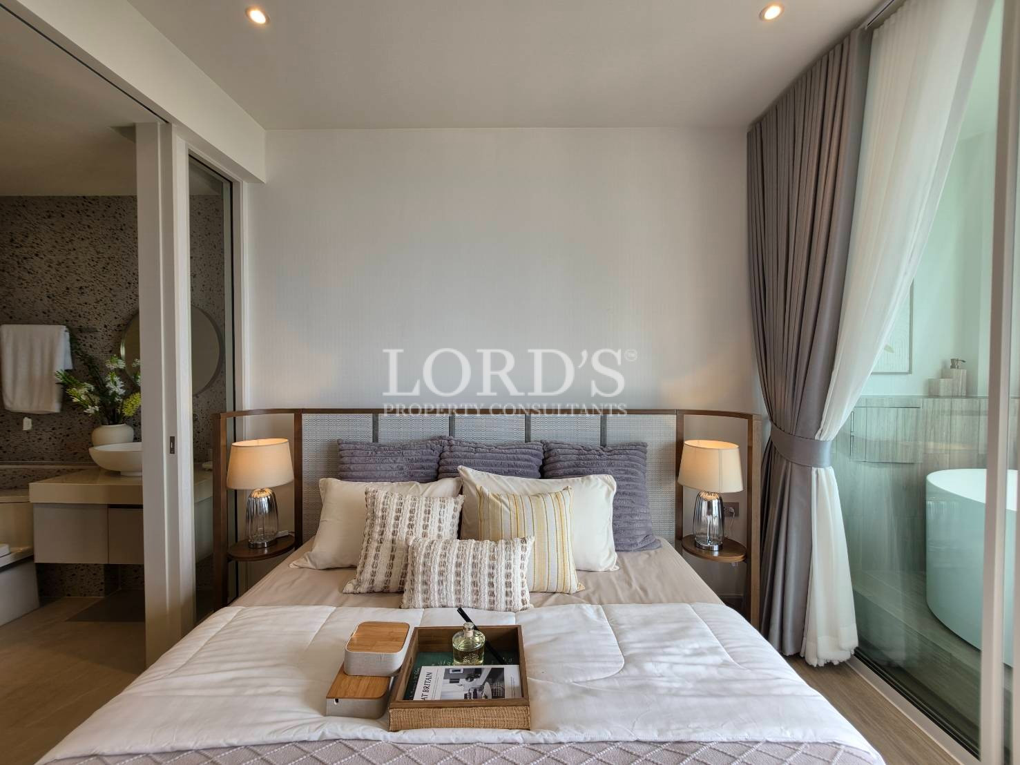 Bright master bedroom with large windows and neutral interior