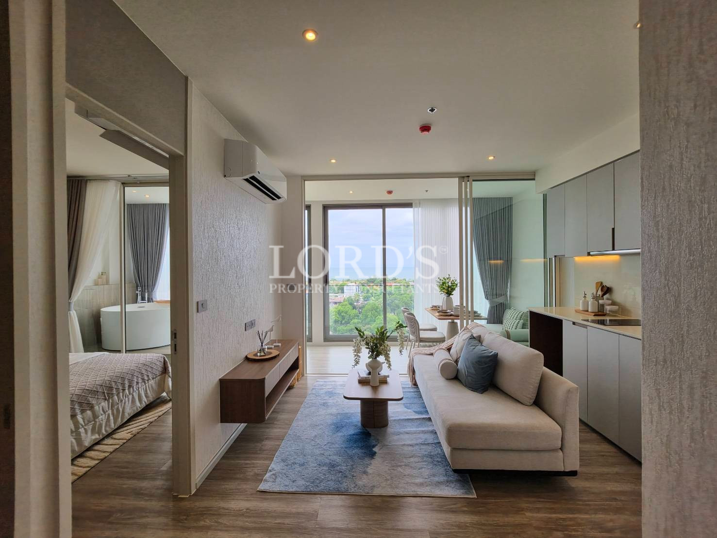 Open-concept living room with large windows and contemporary kitchen