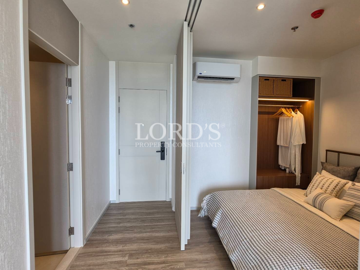 Spacious bedroom with built-in wardrobe, air conditioner, and modern interior