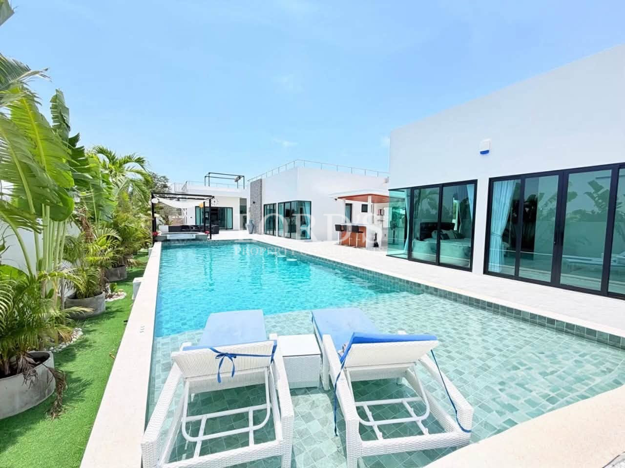 Modern luxury villa with private swimming pool and poolside loungers