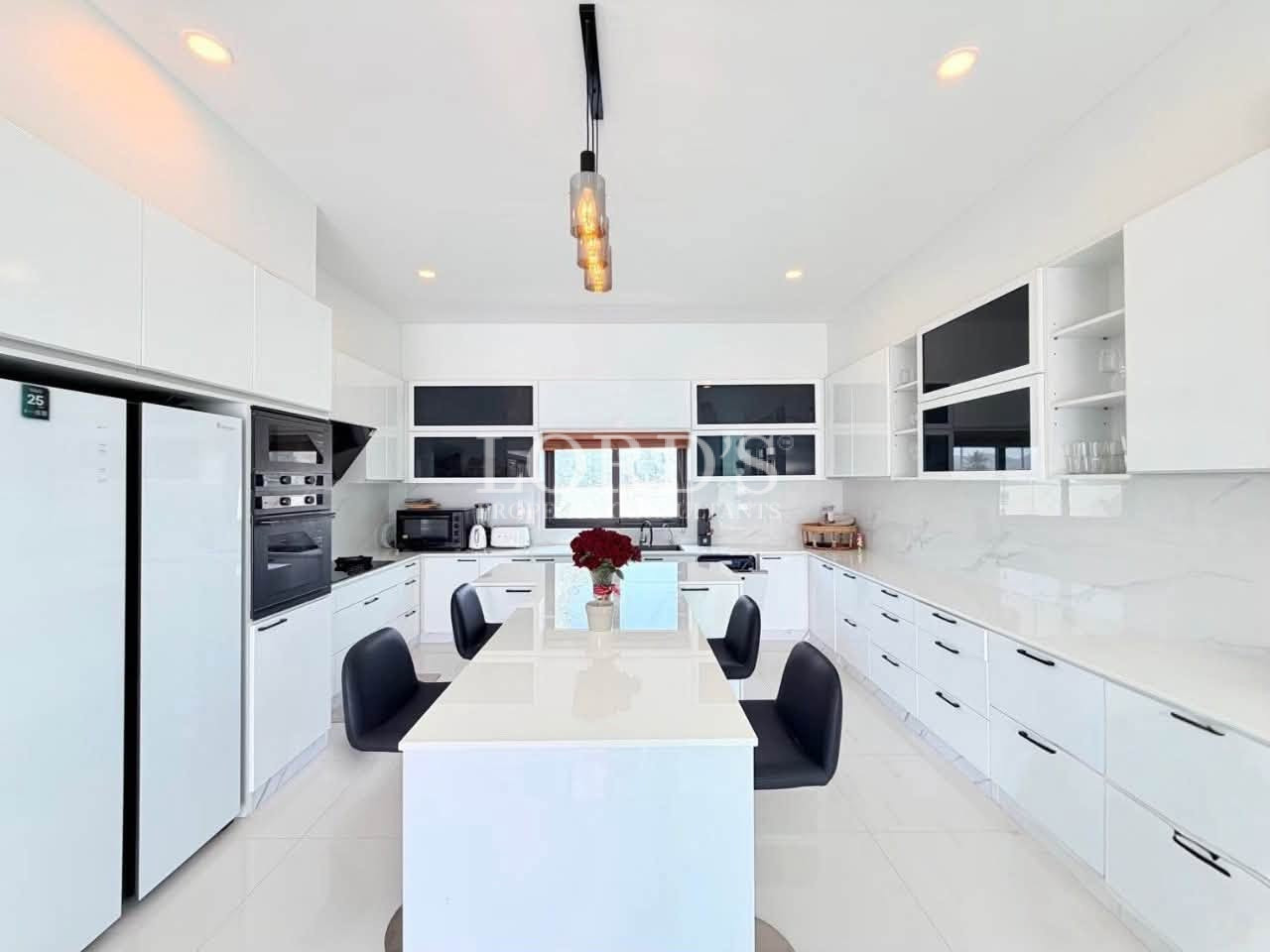 Modern luxury white kitchen with large island and built-in appliances