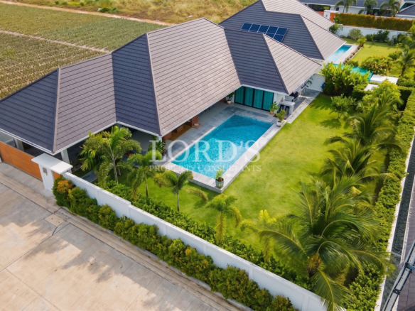 Aerial view of modern luxury villa with private pool and landscaped garden