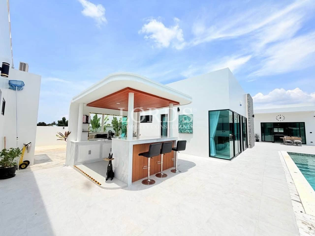 Modern luxury villa with an outdoor bar, pool, and spacious patio