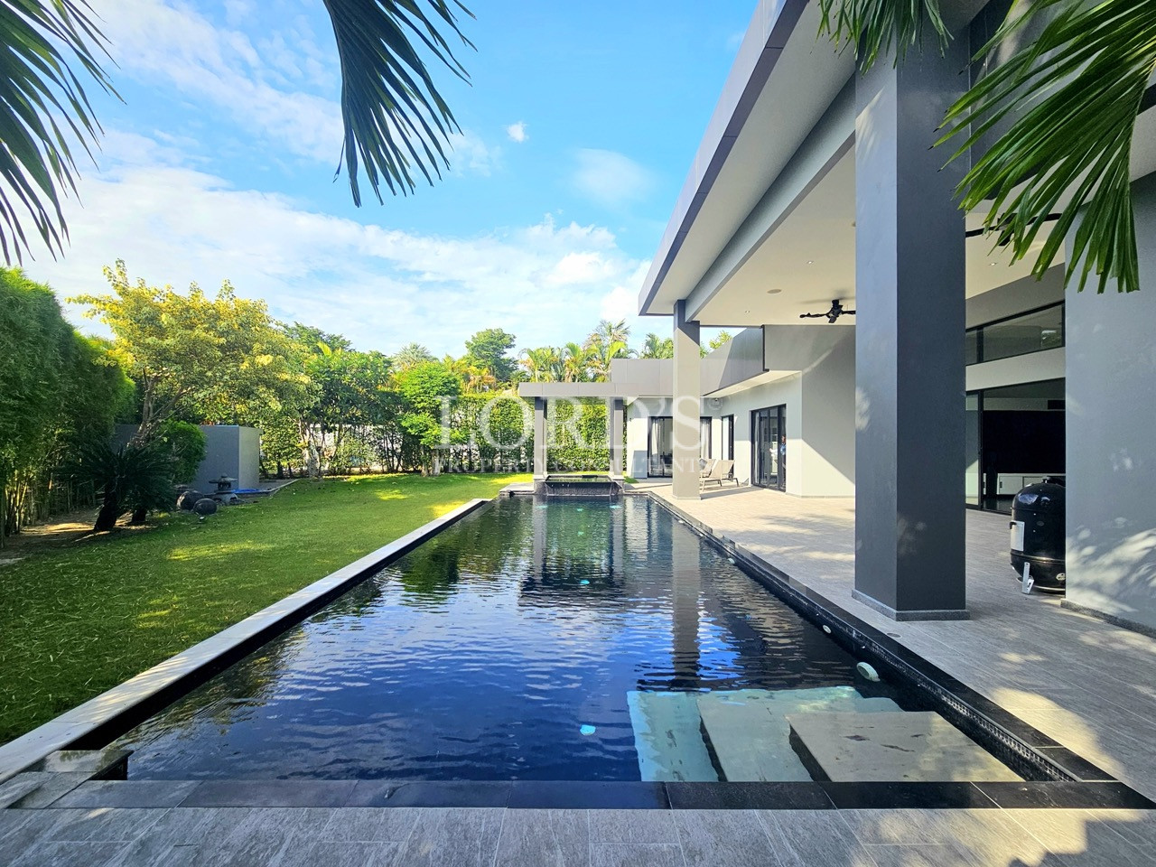 Luxury modern villa with a private swimming pool, covered patio, landscaped garden, and contemporary outdoor living space