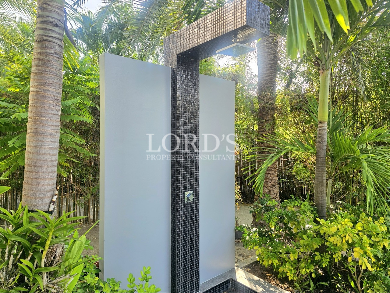Luxury outdoor rain shower surrounded by tropical landscaping and modern resort-style garden design