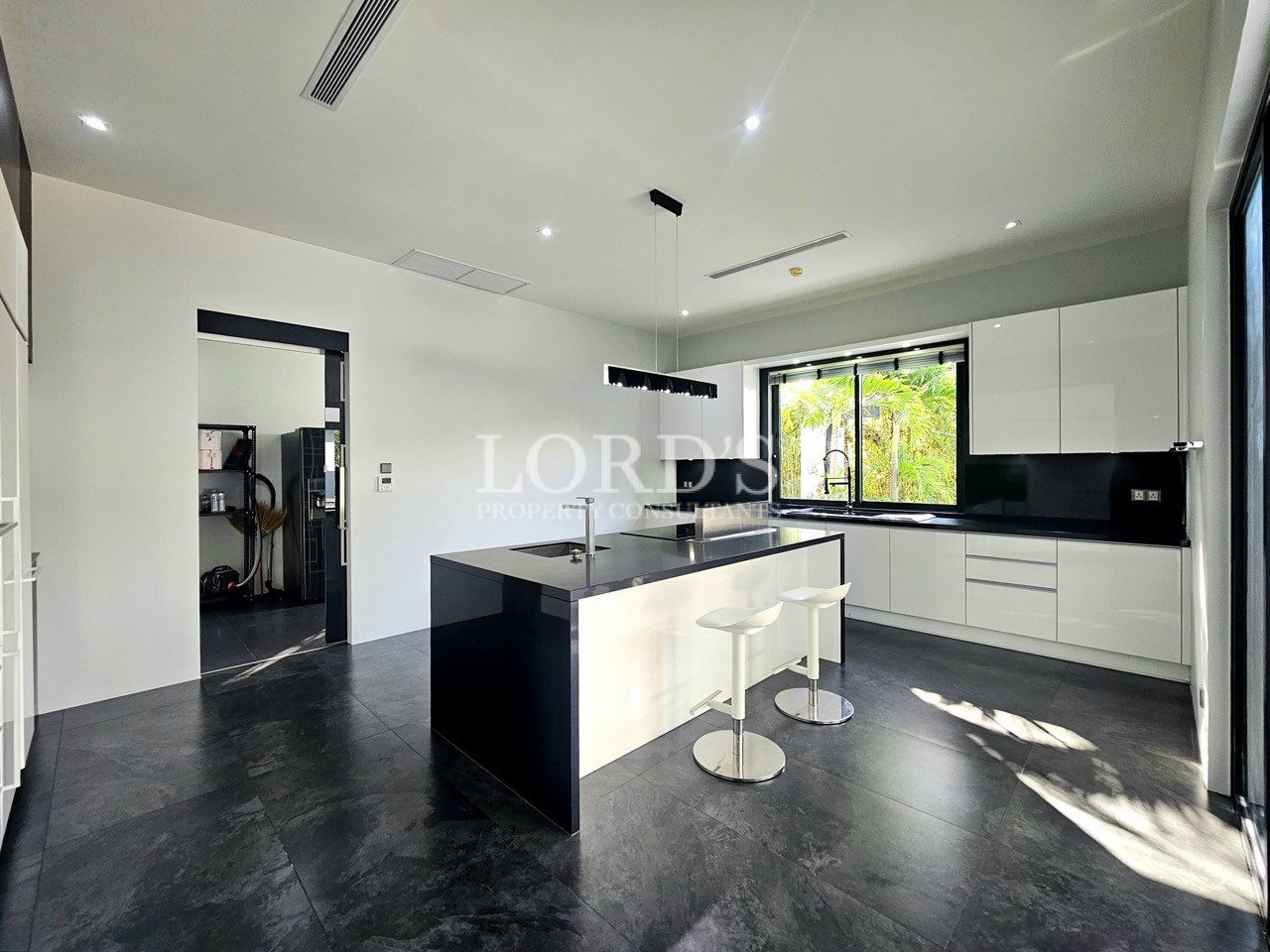 Modern minimalist kitchen with central island, breakfast bar, and glossy white cabinets