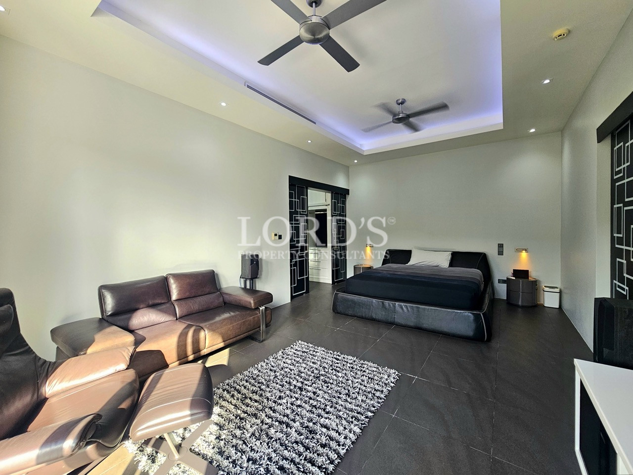 Spacious luxury master bedroom with lounge seating and ensuite access