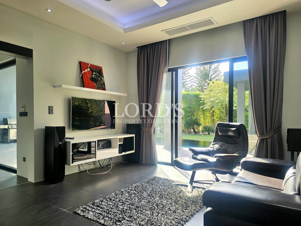 Modern media room with garden views and sliding glass doors