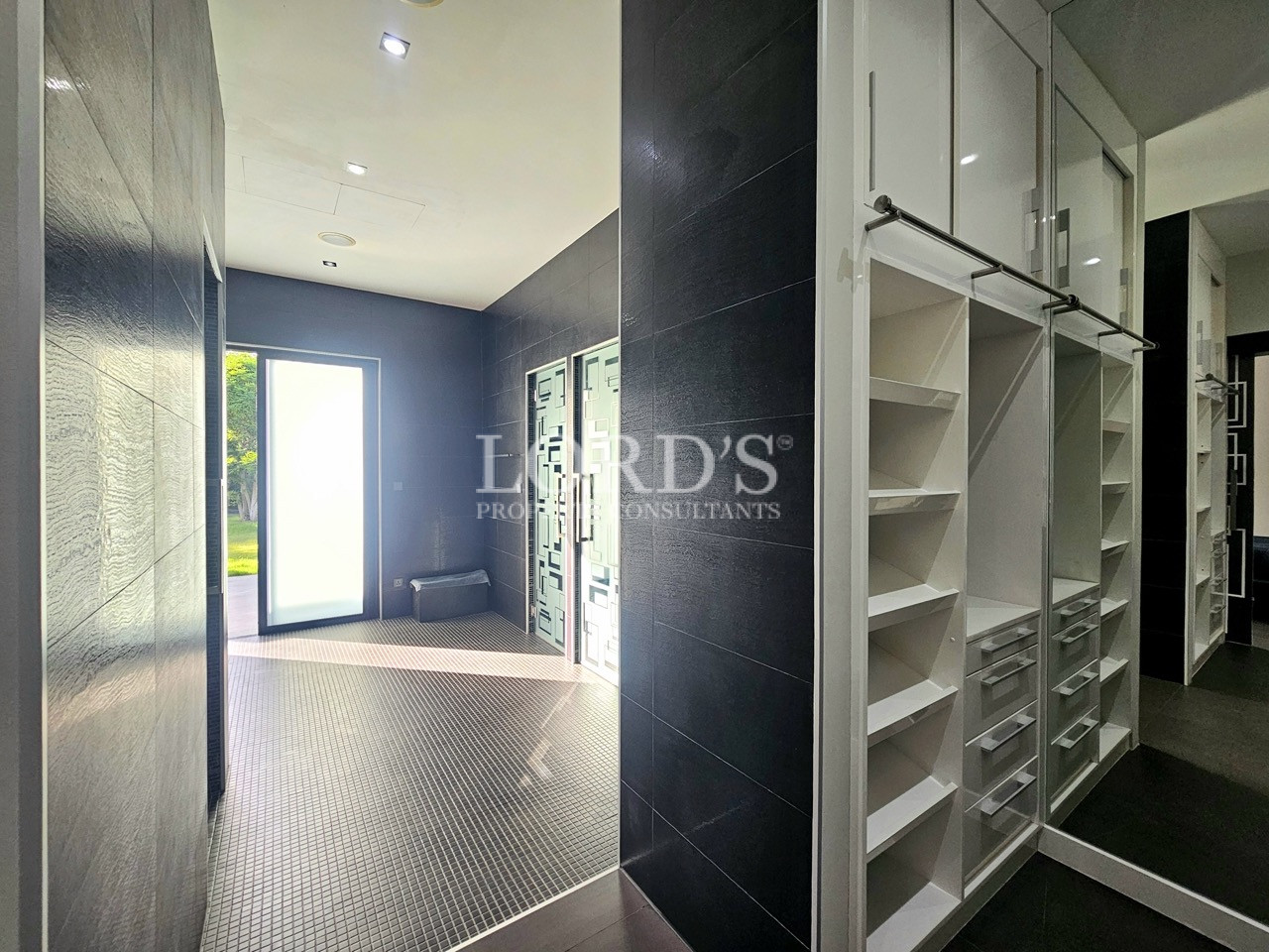 Walk-in wardrobe with custom built-in storage and mirrored cabinets