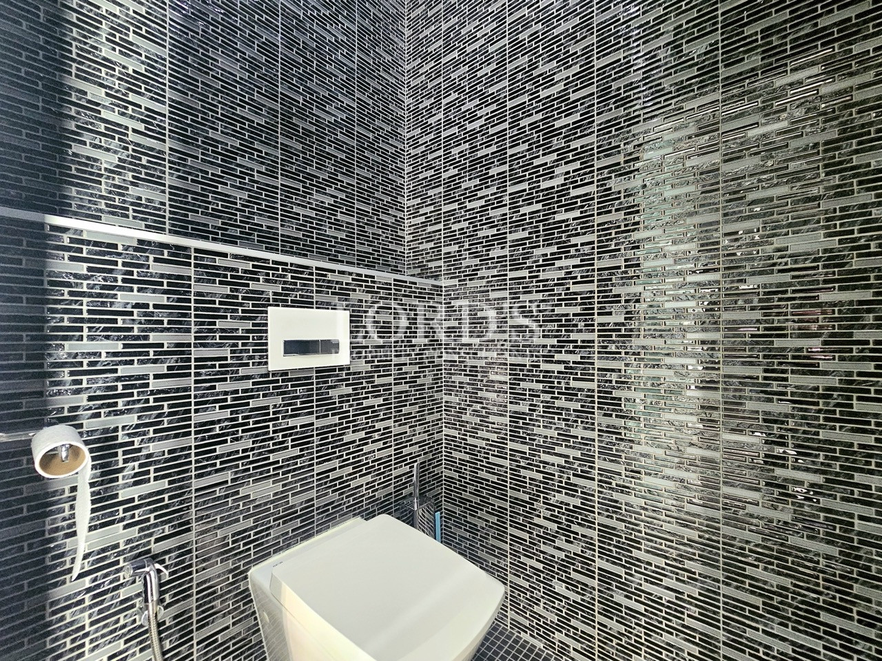 Modern guest bathroom with black mosaic tile walls