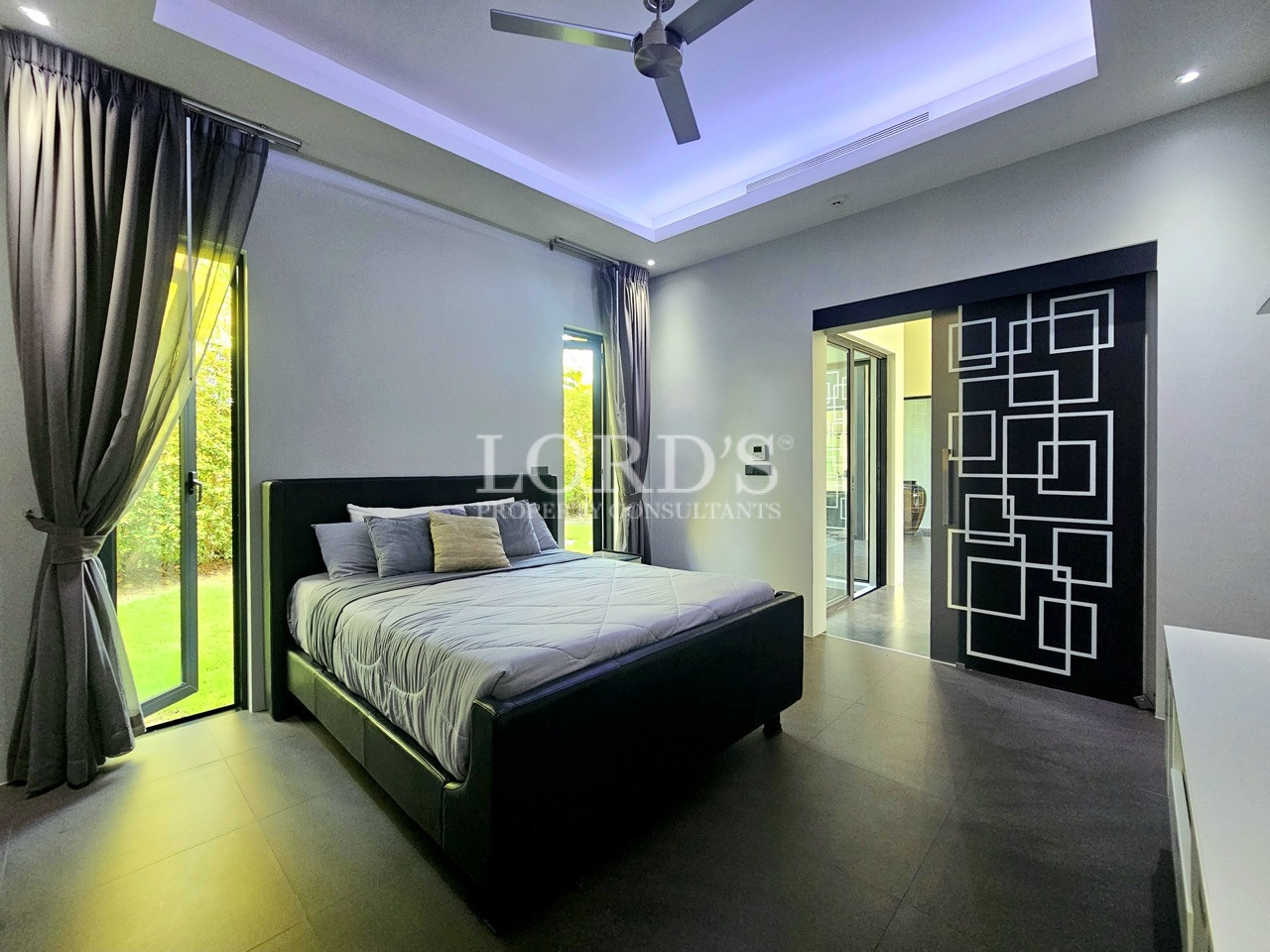 Modern master bedroom with garden views and designer feature door