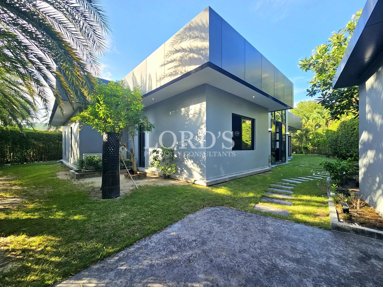 Contemporary villa exterior with landscaped garden and stone pathway