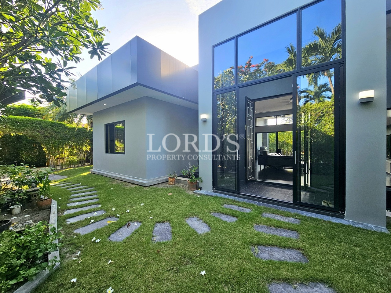 Contemporary villa with double-height glass entrance and landscaped garden