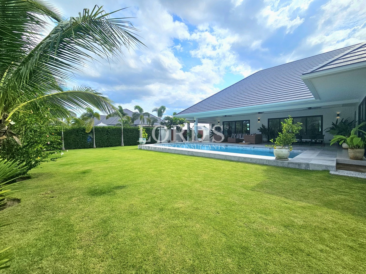 Modern villa with private swimming pool, tropical garden, and spacious lawn