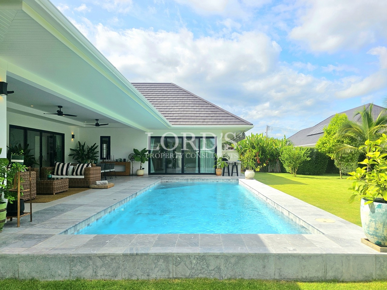 Modern backyard swimming pool with covered patio, garden, and outdoor seating