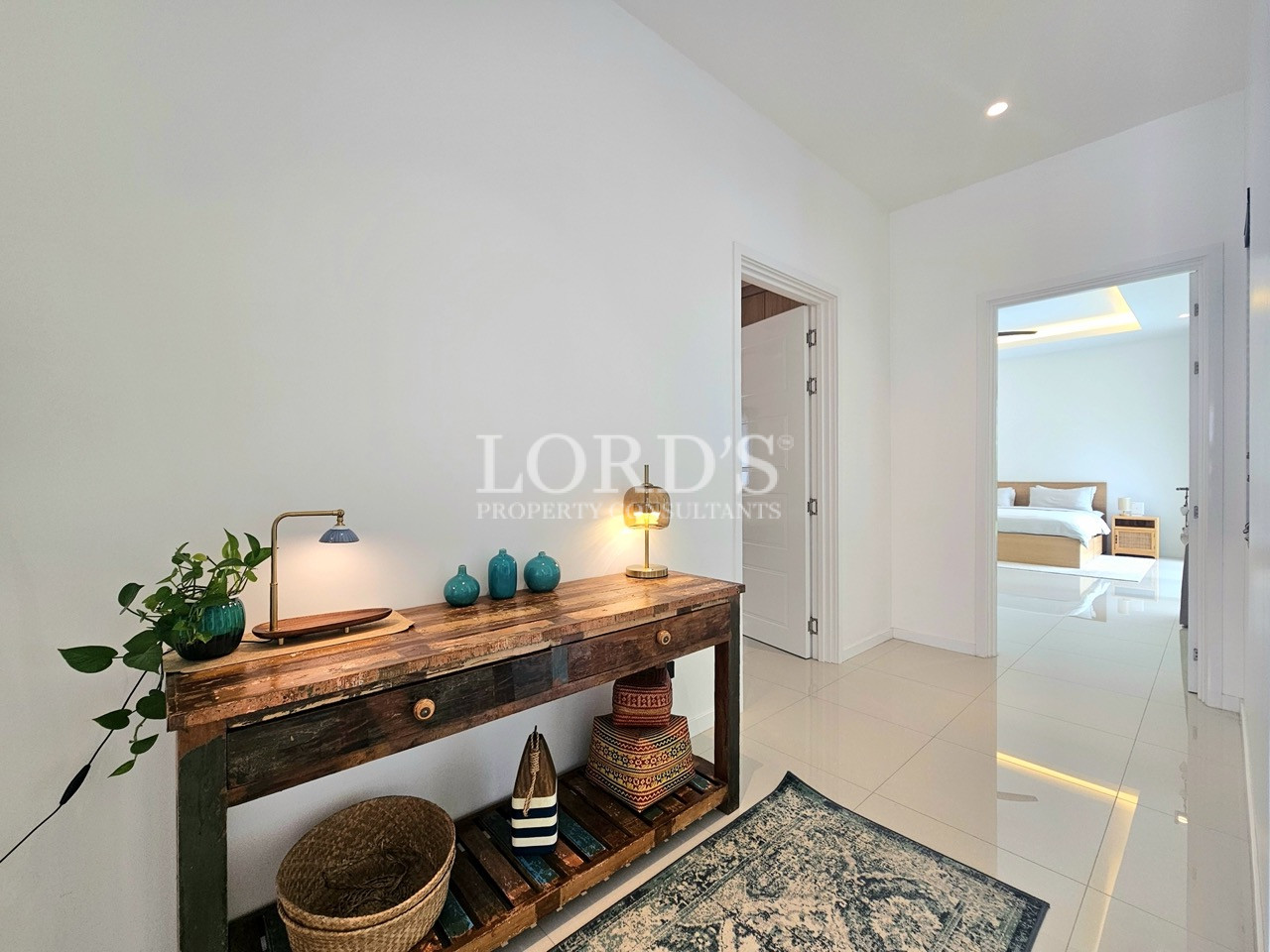 Modern hallway with rustic console table, decorative accessories, and bedroom doorway