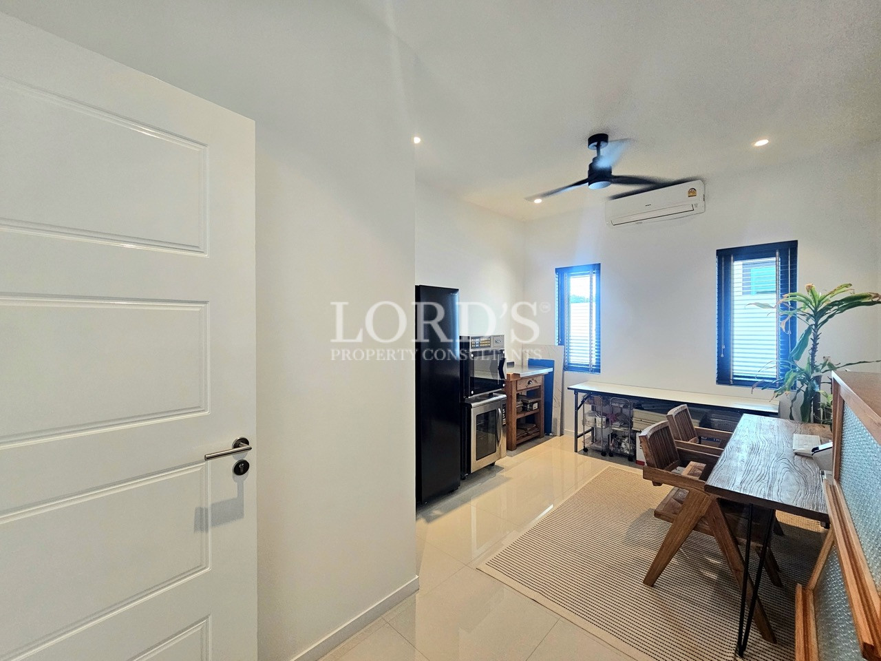 Modern dining and kitchen area with wooden table and built-in appliances