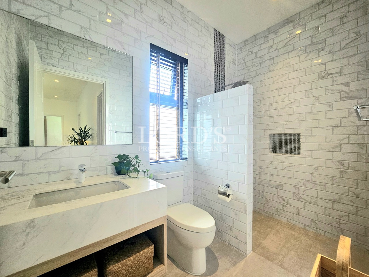 Modern bathroom with walk-in shower, floating vanity, and large mirror