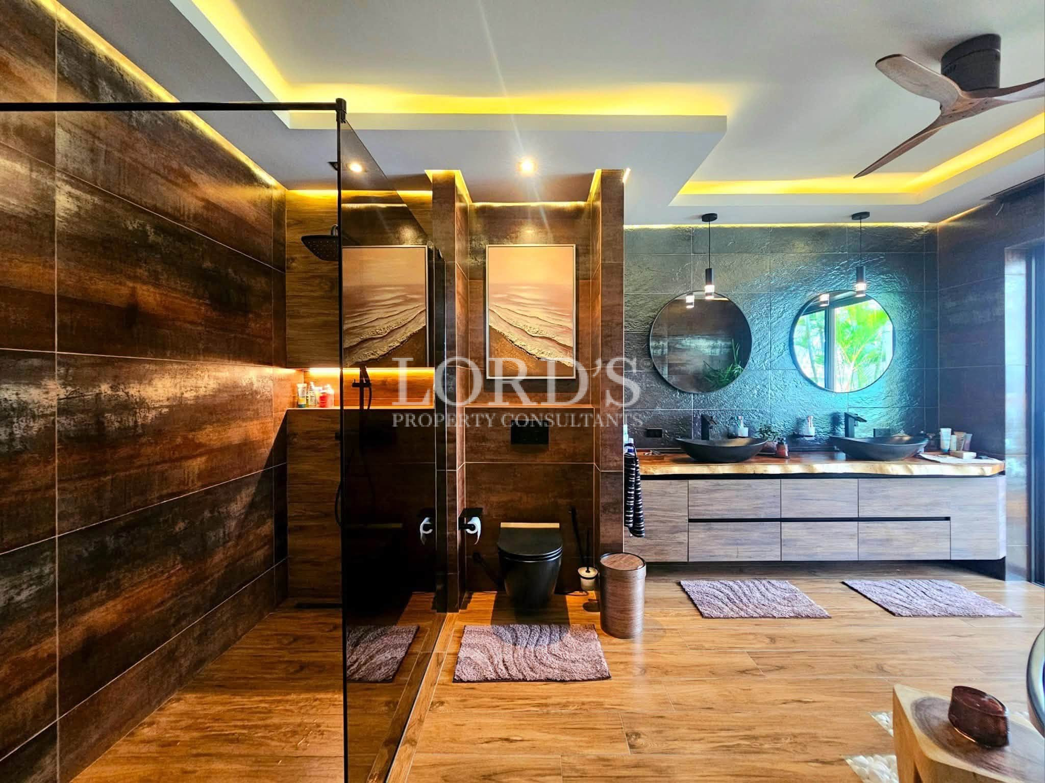 Luxury spa-inspired bathroom with walk-in rain shower, double vessel sinks, floating vanity, and elegant wood finishes