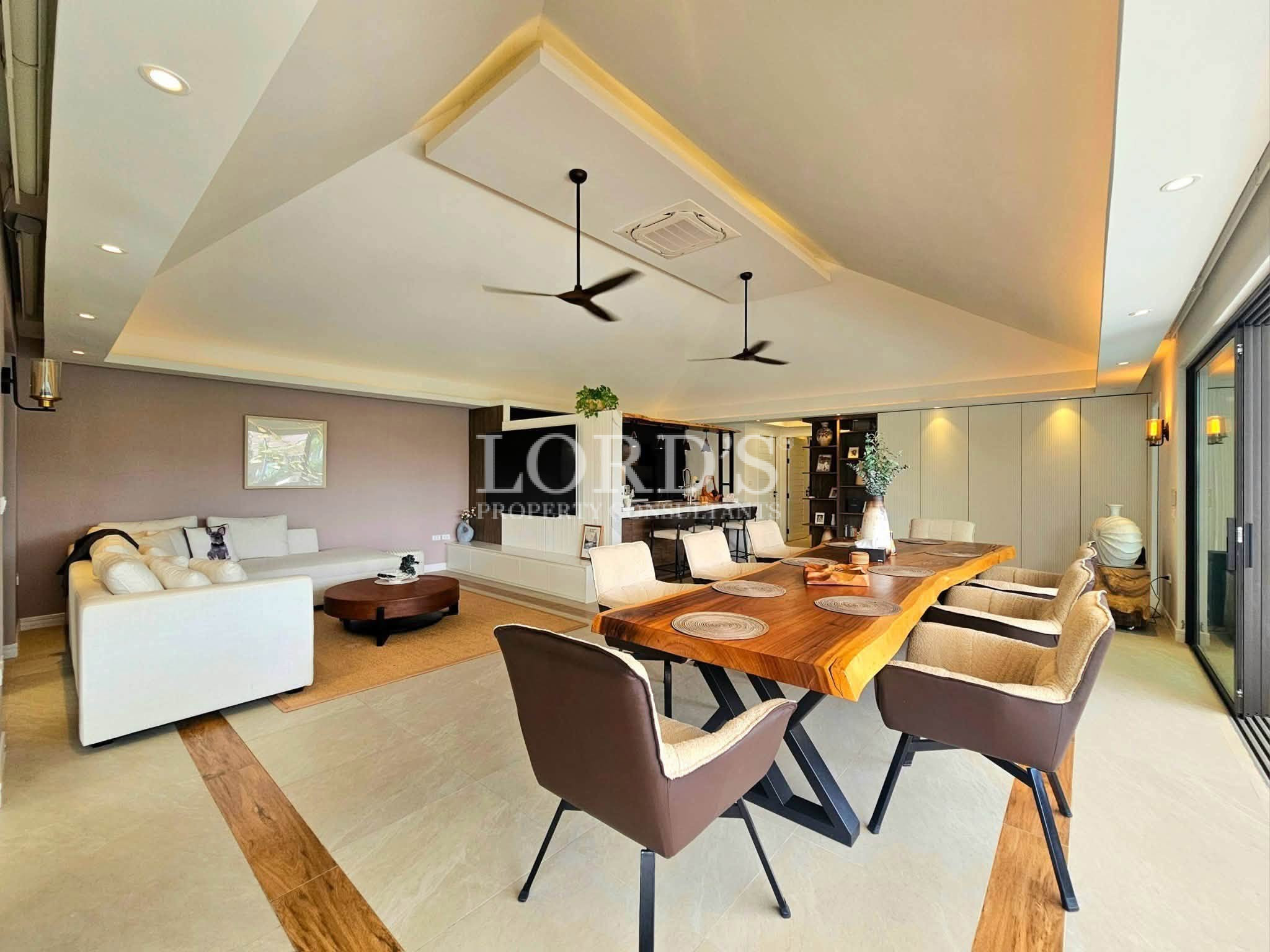 Luxury open-plan living and dining room with a solid wood dining table, modern sectional sofa, and elegant contemporary interior